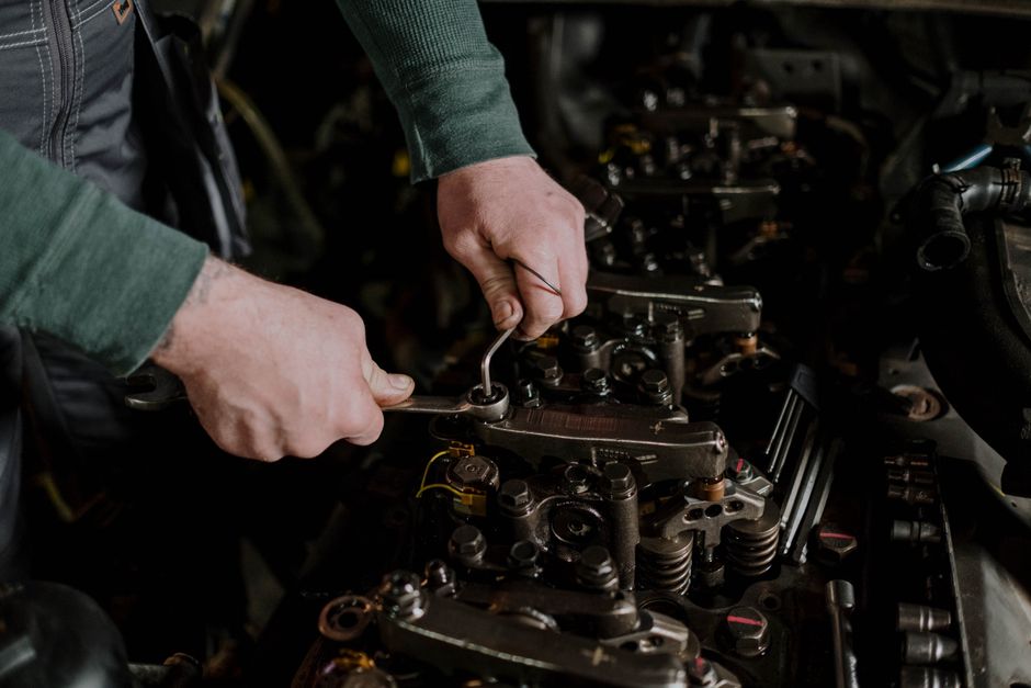 Motor abierto sobre el banco de trabajo con herramientas ordenadas en el taller